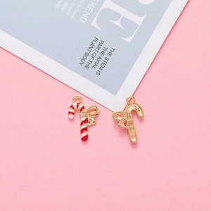 Macro view of Christmas candy cane pendants with red enamel, gold base and rhinestones
