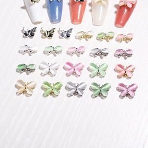Makroaufnahme von 3D-Katzenaugenstein-Schmetterlings-Nagelcharms in verschiedenen Farben