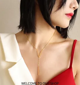 Close-up of minimalist rose gold V-shaped necklace with vertical bar pendant on a model