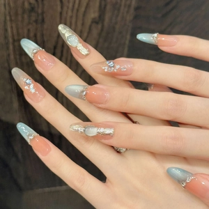 Blue cat-eye press-on nails in long almond shape with silver glitter and rhinestone accents