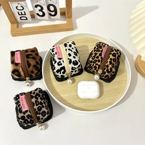 Detailed macro view of four leopard print corduroy cases with white pearl zipper pendants