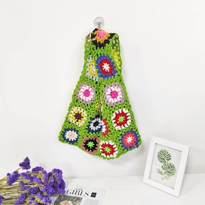 Handmade crochet tote bag with colorful sunflower patterns on green knitted base