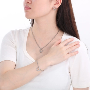 Ensemble collier et bracelet en forme de cœur argenté poli porté par un mannequin