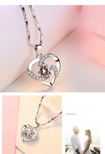 Macro detail of silver heart pendant featuring a central diamond and custom engraving