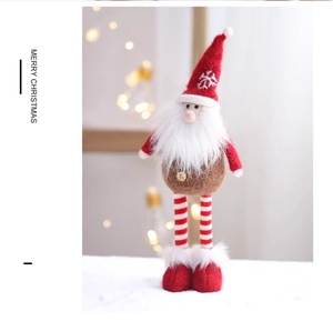 Detail of Christmas long-legged gnome with snowflake hat against festive bokeh lights