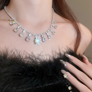 Close-up of a drop tassel zircon necklace worn on neck with black feather outfit