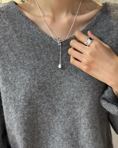 Detail view of 925 silver necklace with pearl pendant and textured irregular ring on model