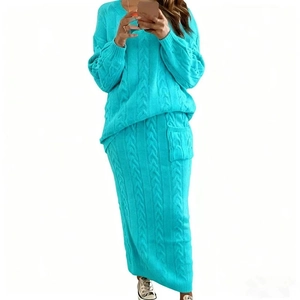 Détail du pull en maille torsadée bleu clair et de la jupe longue assortie pour femme