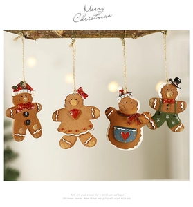 Detailed view of gingerbread man resin ornaments hanging on a rustic branch decoration