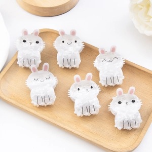 Set of 6 cute white rabbit hair claws with pink ears on a wooden display tray