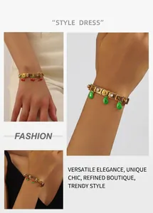 Close-up of gold stainless steel charm bracelet with enamel fruit charms and crystals