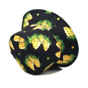 Close-up of black bucket hat with corn pattern print showing detailed fabric texture