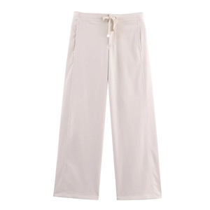 Détail du pantalon large beige avec cordon de serrage réglable et texture côtelée fine