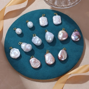 Baroque freshwater pearl pendants with S925 silver gold-plated clasps on teal velvet display