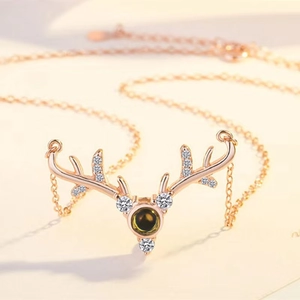 Detailed macro of rose gold antler necklace featuring center projection stone and crystals