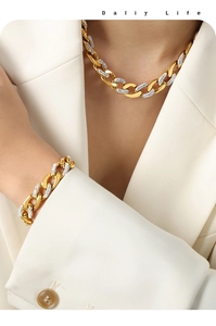 Detail of gold Cuban link jewelry set with pavé diamonds worn over a white blazer