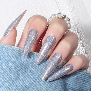 Long stiletto press-on nails with silver holographic laser glitter on denim fabric
