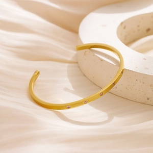 Macro shot of 18k gold plated stainless steel cuff bracelet with pink zircon stones