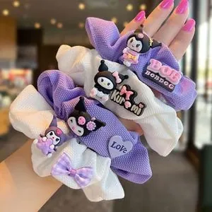Detail of purple and white waffle fabric scrunchies featuring cute cartoon resin charms