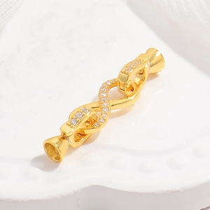 Macro shot of gold infinity jewelry clasp with sparkling white zircon stones for necklaces