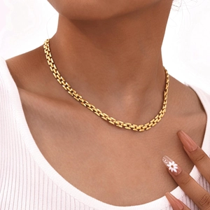 Modern wide gold link chain necklace for women shown on neck over white ribbed top