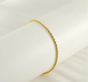 Detail of 18k gold plated stainless steel rope chain ankle bracelet with spiral texture