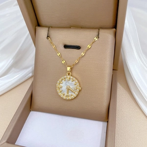 Luxurious gold stainless steel shell clock necklace with rhinestones on a satin background