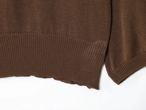 Close-up of tight ribbed cuffs and hem texture on dark coffee knit sweater top