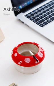 Detailopname van paddenstoel asbak van keramiek met rood deksel op een modern bureau