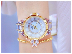 Detail of luxury women's watch with rhinestone bezel and mother of pearl flower dial