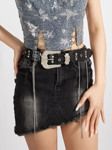 Detail of black leather belt with rhinestone butterfly buckle and metal hanging chains