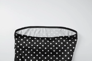 Gros plan du tissu à pois noir et blanc avec détails de couture de haute qualité aux bords