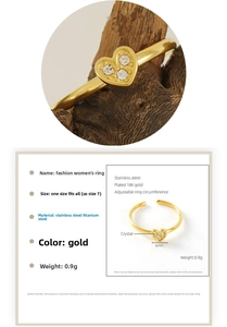 Detail view of 18K gold plated heart ring with zircon inlay on a natural wood surface