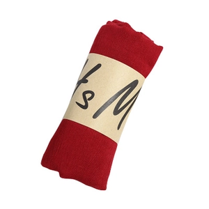 Solid red cotton linen scarf with pleated texture in a minimalist paper wrap roll