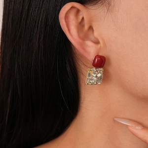 Close-up of vintage red acrylic and rhinestone geometric earrings on a model