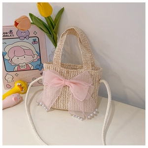Close-up of beige straw bag with pink tulle bow, pearl accents, and woven texture