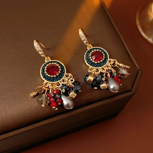 Details von Vintage-Goldohrringen mit roten Steinen, Perlen und bunten Perlenquasten