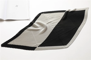 Macro detail of black and white pleated silk scarf with rhombus pattern and fine texture