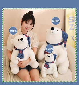 Three sizes of white Christmas polar bear plush toys with blue scarfs shown with a model