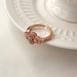 Anello aperto fiore in oro rosa con zirconi scintillanti su ceramica a rilievo bianco