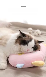 Detail eines rosa Plüsch-Haustierkissens mit Stickerei und einer schlafenden Katze