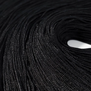 Vue rapprochée des détails complexes de la frange tissée noire sur la robe de luxe