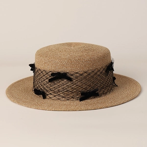 Detail of flat top straw boater hat with black mesh veil and ribbon bows decor