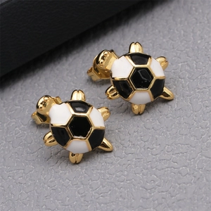 Detail of gold turtle earrings featuring a black and white football patterned shell