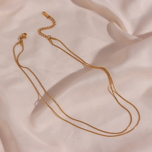 Close-up of dual-layer gold snake chain necklace with lobster clasp and K18 hallmark tag
