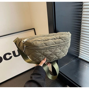 Detail of army green quilted crossbody bag with nylon texture and metal zipper