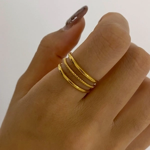 Three-layered gold stacked stainless steel ring displayed on finger for women