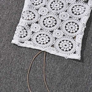 Dettaglio del tessuto in pizzo floreale bianco con intricati motivi all'uncinetto