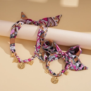 Detail of silk scarf hair ties with gold flower pendants and colorful abstract prints