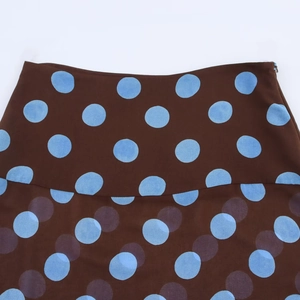 Detailed view of polka dot top featuring dual-layer fabric and brown organza overlay